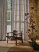 Luxury collection by Christopher Farr Cloth featuring two upholstered chairs in Dodma and Mawamba fabrics in ochre mustard, deep reds, and terracotta, with Circus piping edges, viewed from above on a green and grey rug.
